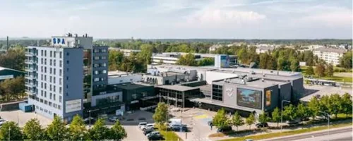 Katuseremont Viimsis, ülalt vaade SPA-sildiga kõrghoonele ja kaubanduskeskuse lamekatustele, katuseserva kinnitused kontrollitakse tõmbeprooviga.